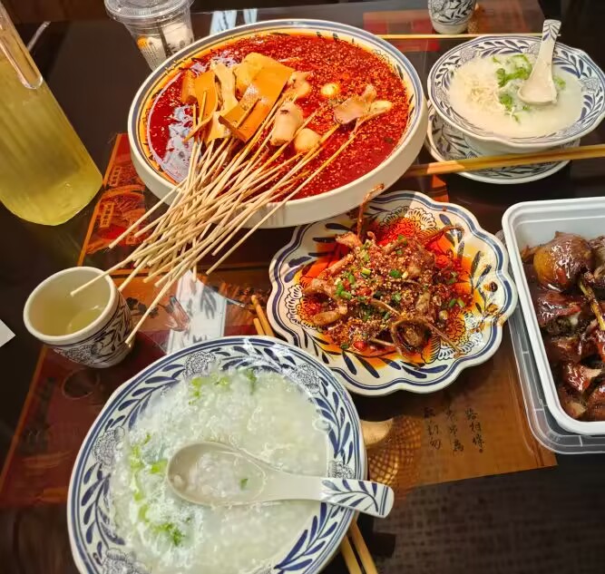 第一顿快结束才拍。红油、竹签和两碗鸡汤饭把桌面占得很满。